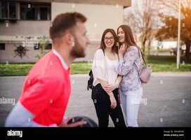 two-pretty-high-school-girls-having-a-conversation-and-laughing-while-looking-at-older-basketb...jpg