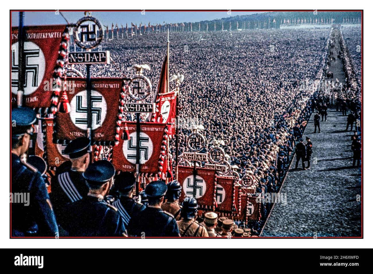 1930s-nsdap-banner-und-hakenkreuz-emblem-im-vordergrund-in-farbe-mit-transparenten-und-fahnen-im-uberfullten-hauptaula-im-freien-mit-tausenden-von-nazi-parteiunterstutzern-und-seltenen-farbbildern-mit-nsdap-bannern-und-hakenkreuz-emblem-im-vordergrund-die-nazi-partei-offiziell-die-nationalsozialistische-deutsche-arbeiterpartei-nsdap-war-eine-rechtsextreme-politische-partei-in-deutschland-die-zwischen-1920-und-1945-aktiv-war-und-die-ideologie-und-propaganda-des-nationalsozialismus-und-der-nazi-partei-unter-der-fuhrung-des-fuhrers-adolf-hitler-nazi-deutschland-schuf-und-unterstutzte-2h6xwfd.jpg