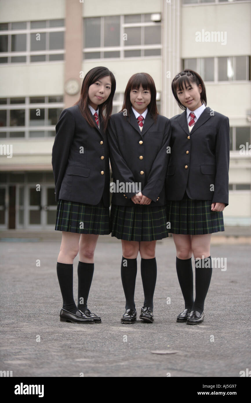 three-high-school-girls-standing-in-schoolyard-AJ5G97.jpg