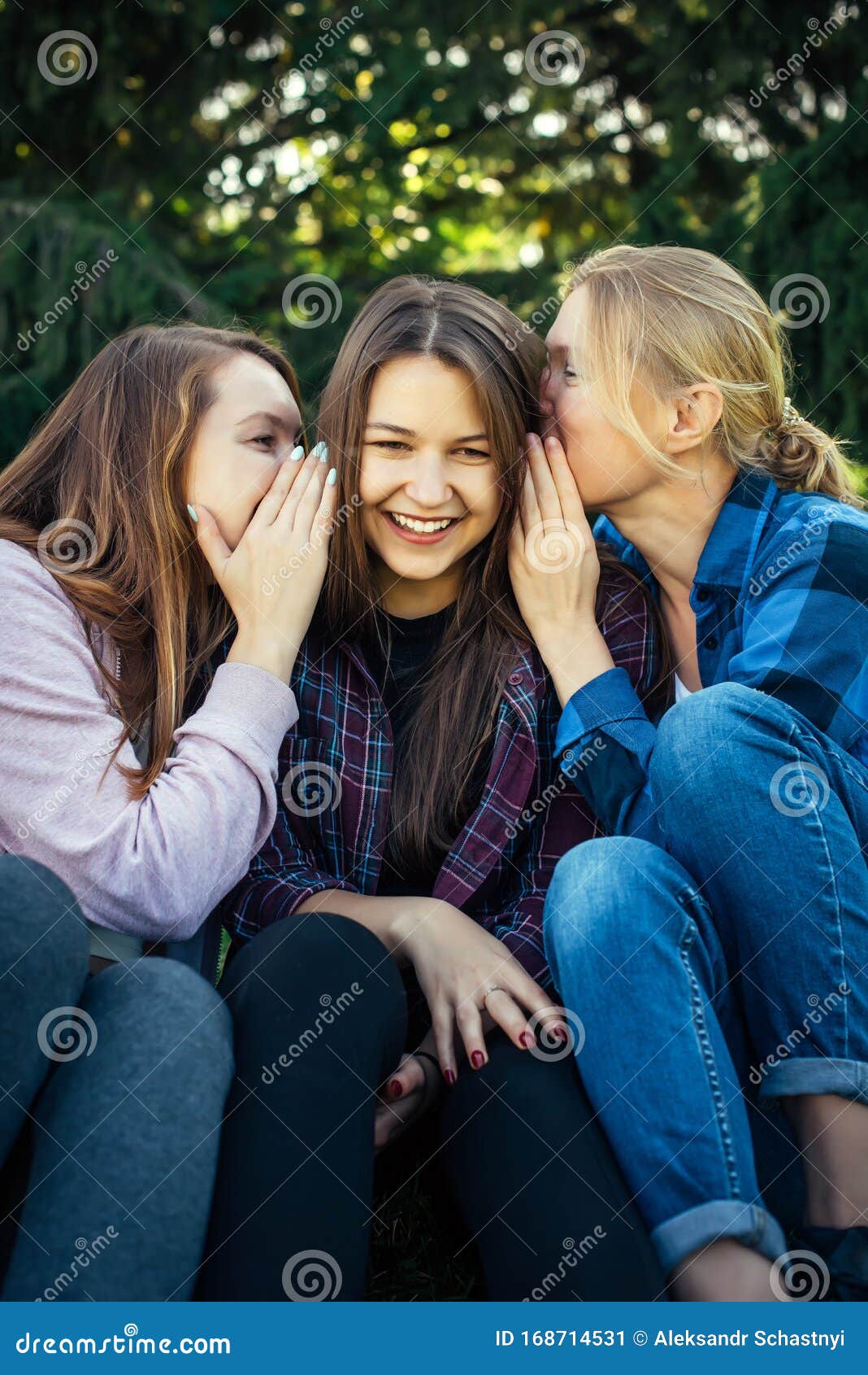 three-cheerful-girls-whisper-gossip-against-green-foliage-park-women-joke-laugh-vertical-image-three-cheerful-girls-168714531.jpg