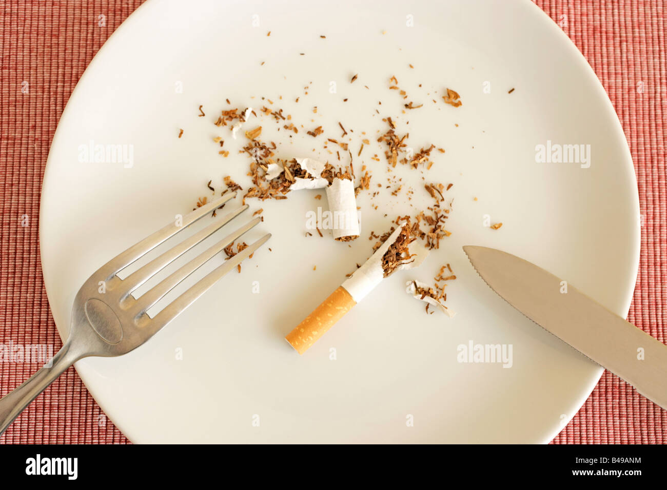Torn up cigarette on plate with knife and fork Stock Photo - Alamy