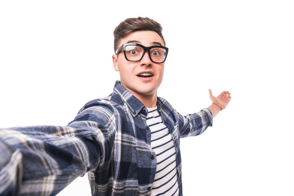 A man with glasses in a blue checked shirt taking a selfie.