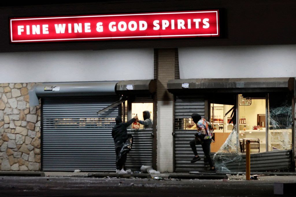 People breaking into a liquor store during the night of vandalism.