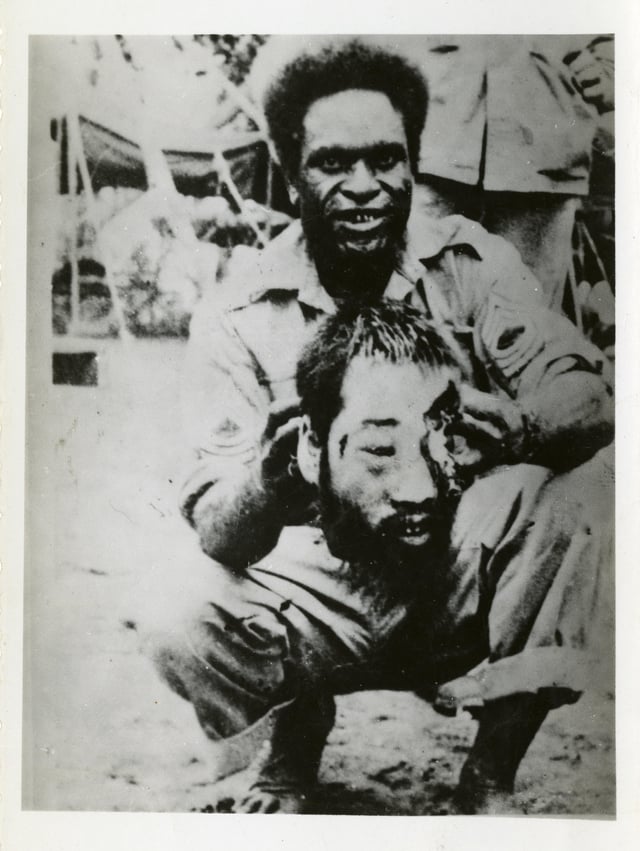 r/MorbidReality - A Papuan soldier holds the decapitated head of a Japanese soldier, 1945
