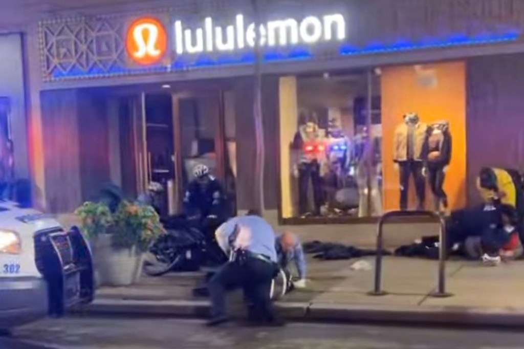 Police officers are seen tackling shoplifters outside the ransacked Lululemon store in Rittenhouse Square