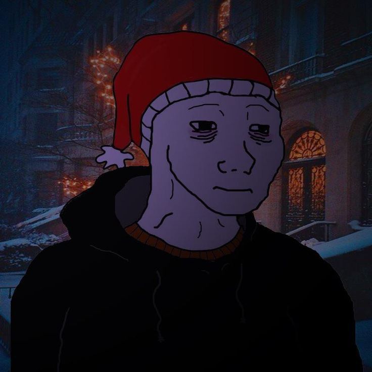 This may contain: a man wearing a red hat in the dark with snow on his head and buildings behind him