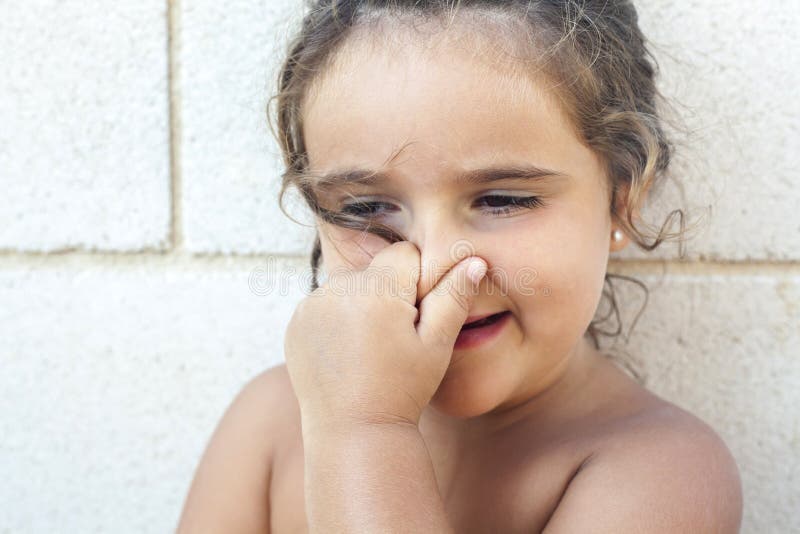 girl-touching-her-nose-white-stone-wall-68900575.jpg