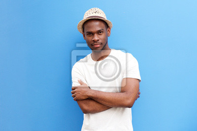 cool-young-black-guy-with-hat-posing-with-arms-crossed-against-blue-background-400-167919247.jpg