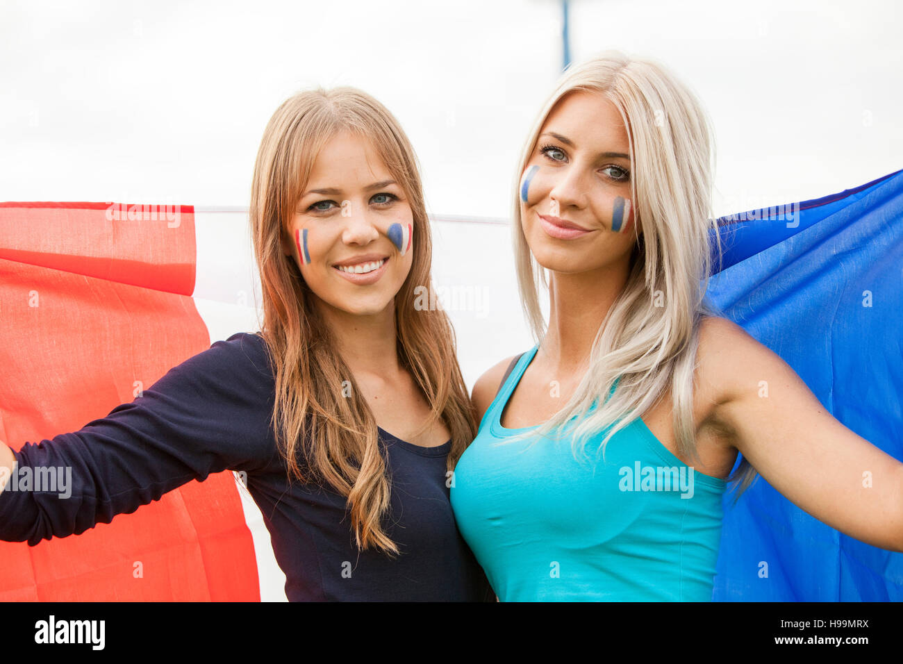 two-young-women-holding-french-flag-H99MRX.jpg