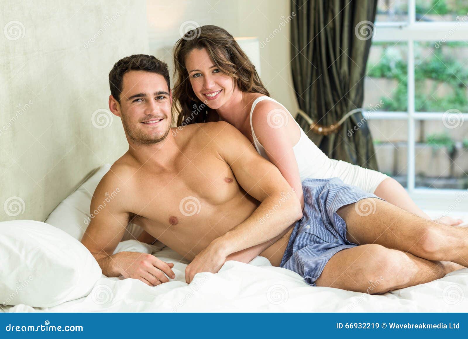 young-couple-cuddling-bed-portrait-bedroom-66932219.jpg