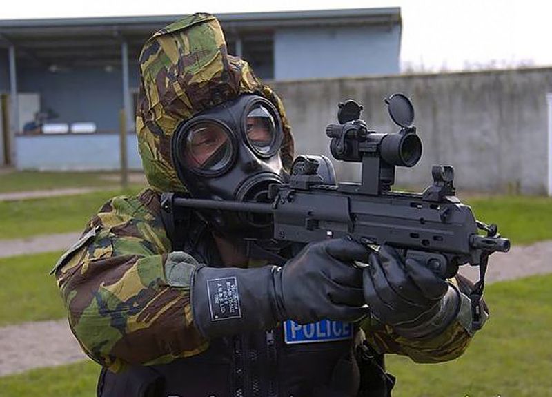 MoD Police officer on range with an MP7-SF in CBRN suit.