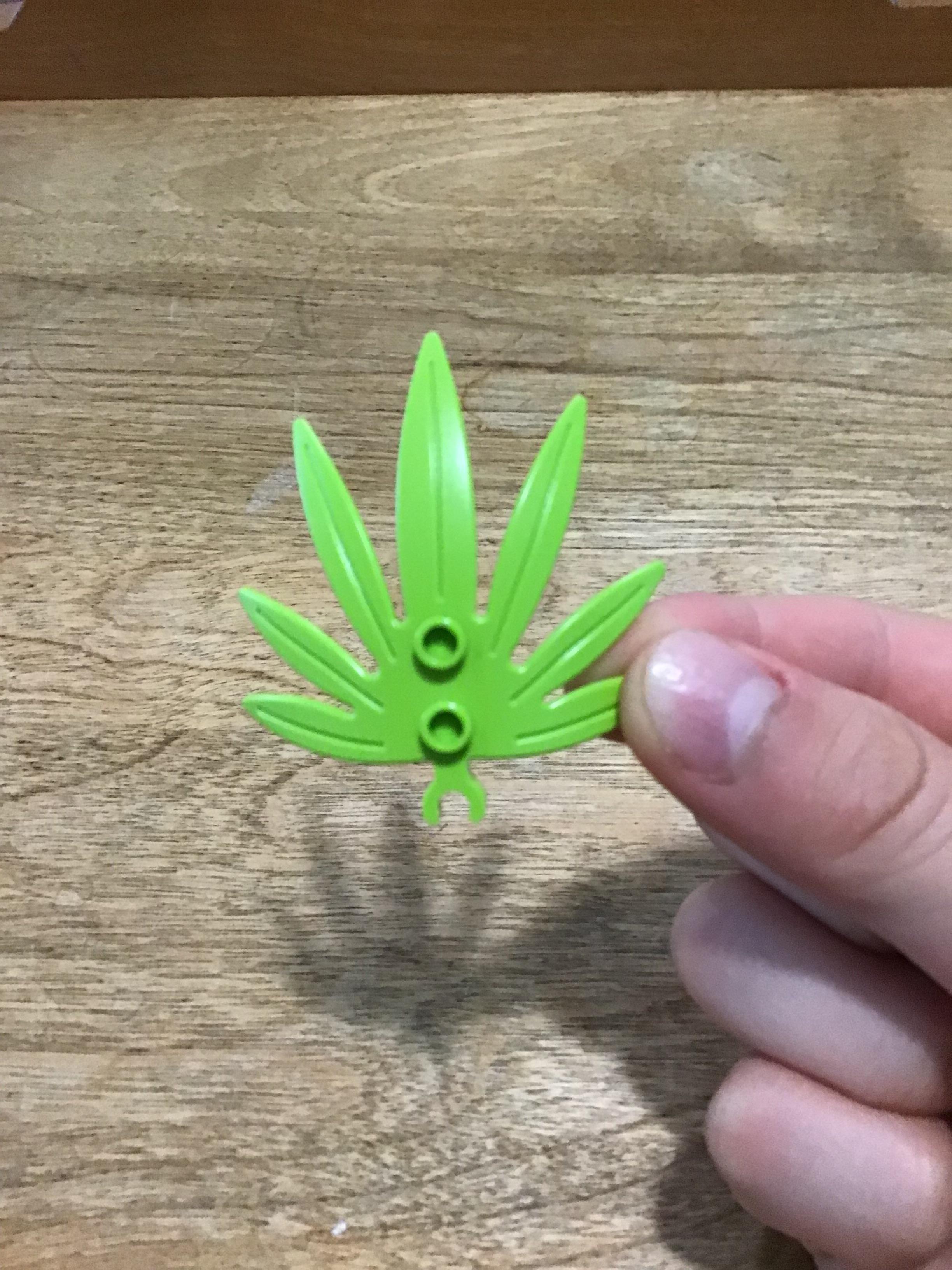 r/lego - a hand holding a green leaf shaped object