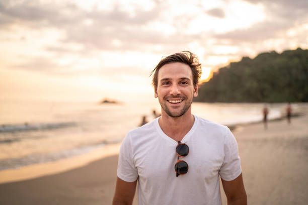 portrait of men smiling at the beach - attractive men stock pictures, royalty-free photos & images