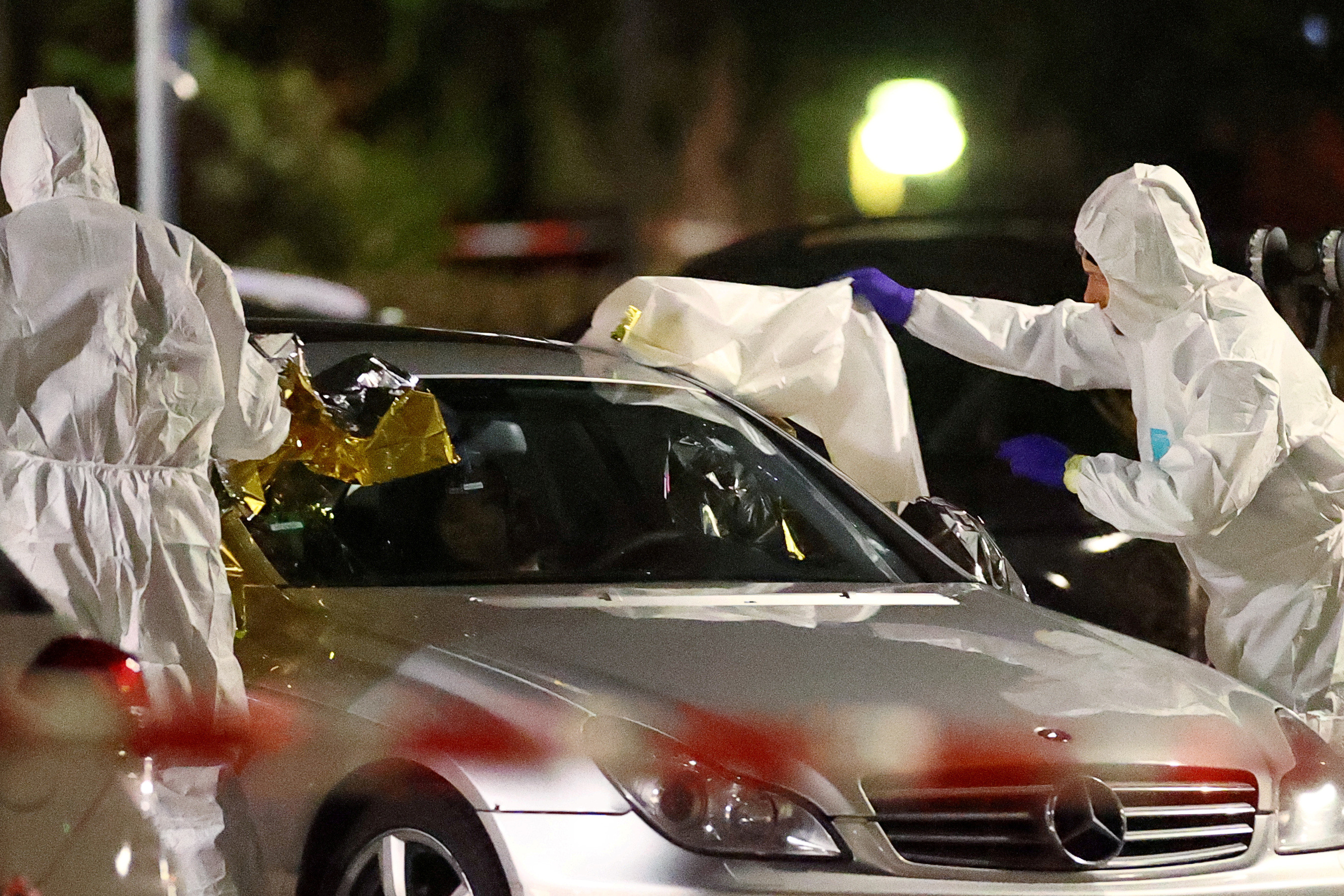 Police can be seen examining a silver Mercedes where the shooting unfolded Police can be seen examining a silver Mercedes where the shooting unfolded