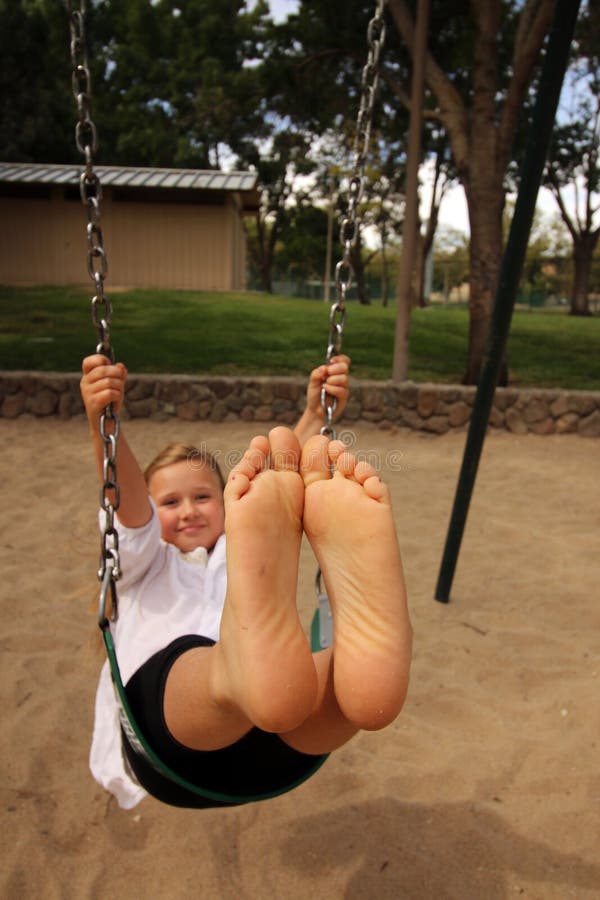 girl-his-feet-toether-air-swinging-her-swing-57547219.jpg