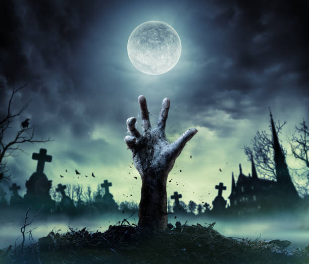 zombie-hand-rising-out-of-a-grave-picture-id849128594