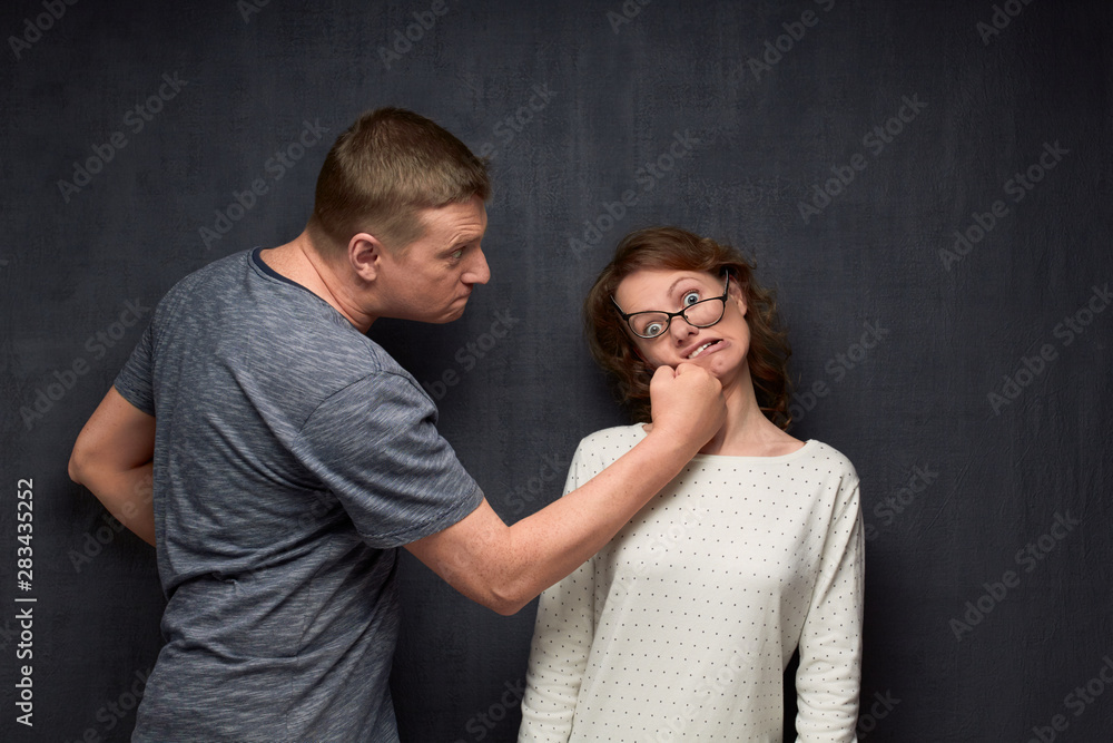 Shot of furious man punching woman with skewed glasses Stock Photo | Adobe  Stock