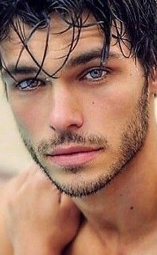 a shirtless man with wet hair and blue eyes