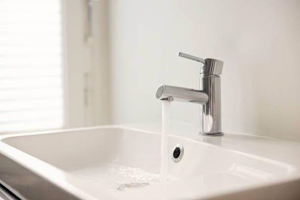 water pouring from sink faucet - sink stock pictures, royalty-free photos & images