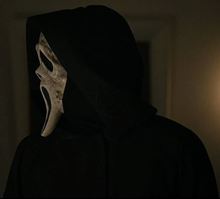 This may contain: a person in a black hoodie with a white mask on their face and mouth
