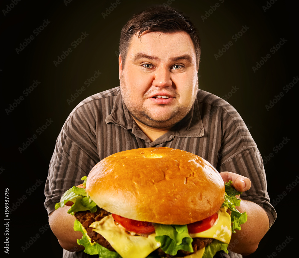 Stockfoto Man eating fast food hamberger. Fat person made great huge  hamburger and admires him, intending to eat it. Junk meal leads to obesity.  Health problems due to malnutrition. | Adobe Stock