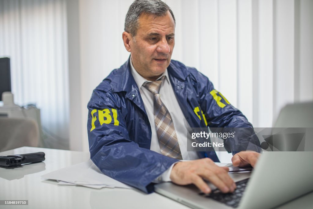 an-old-fbi-agent-uses-a-laptop-in-the-office.jpg