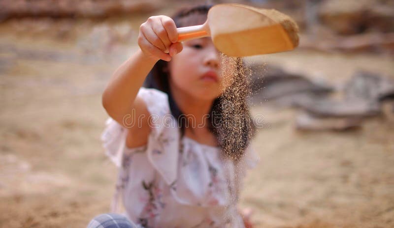 asian-girl-playing-sandbox-sprinkling-sand-small-shovel-young-asian-girl-playing-sandbox-sprinkling-sand-159570842.jpg