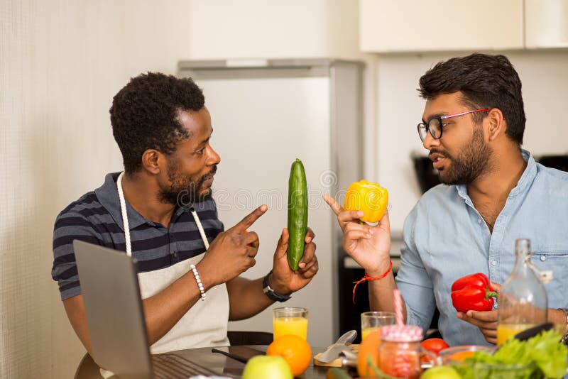 two-man-using-laptop-kitchen-handsome-african-american-young-his-indian-friend-sitting-table-holding-vegetables-156930653.jpg