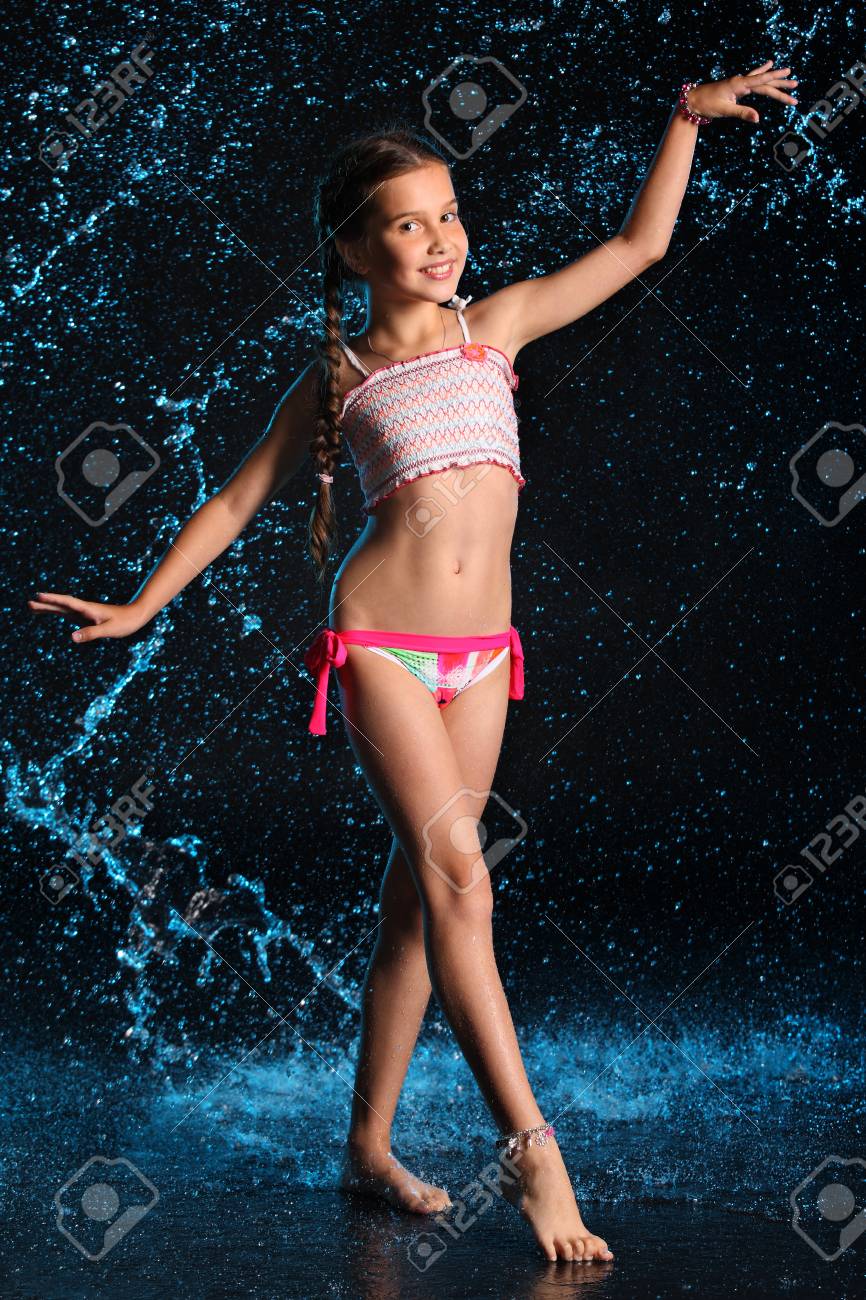 93322453-happy-young-teenage-girl-in-a-swimsuit-stands-barefoot-in-splashing-water-pretty-child-with-dark-hai.jpg
