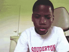 a young man sitting in front of a laptop computer
