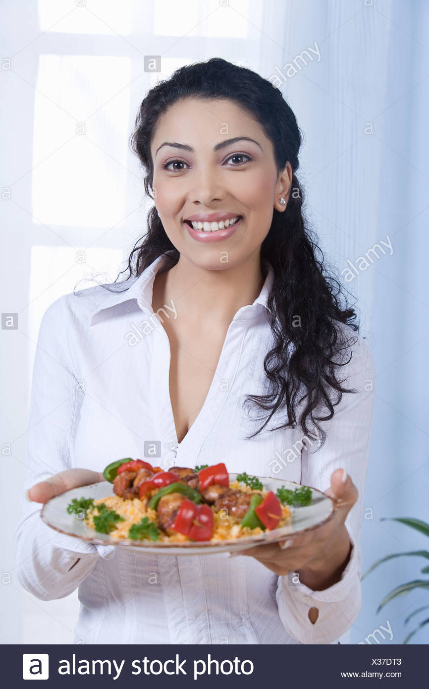 young-woman-holding-food-in-plate-portrait-X37DT3.jpg