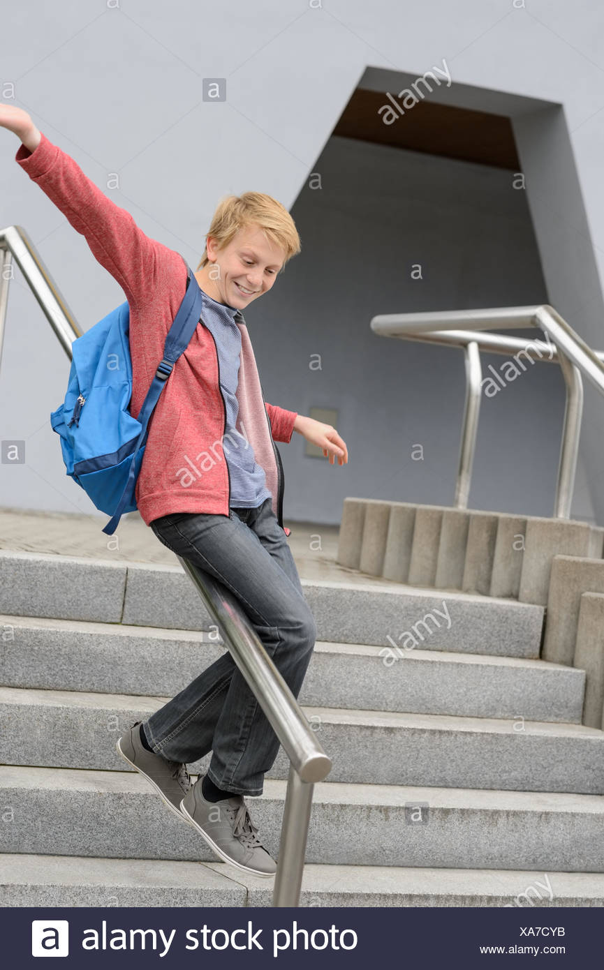 student-sliding-down-railing-on-stairway-XA7CYB.jpg