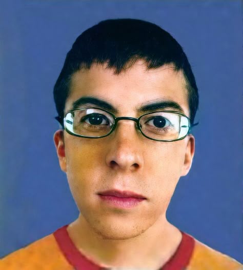 This may contain: a young man with glasses looking at the camera
