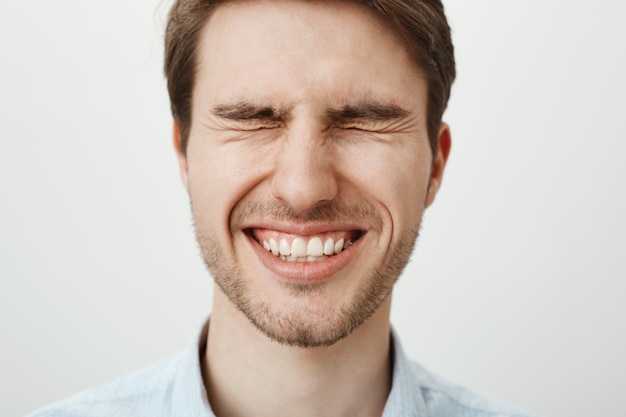 Happy smiling handsome man with closed eyes | Free Photo