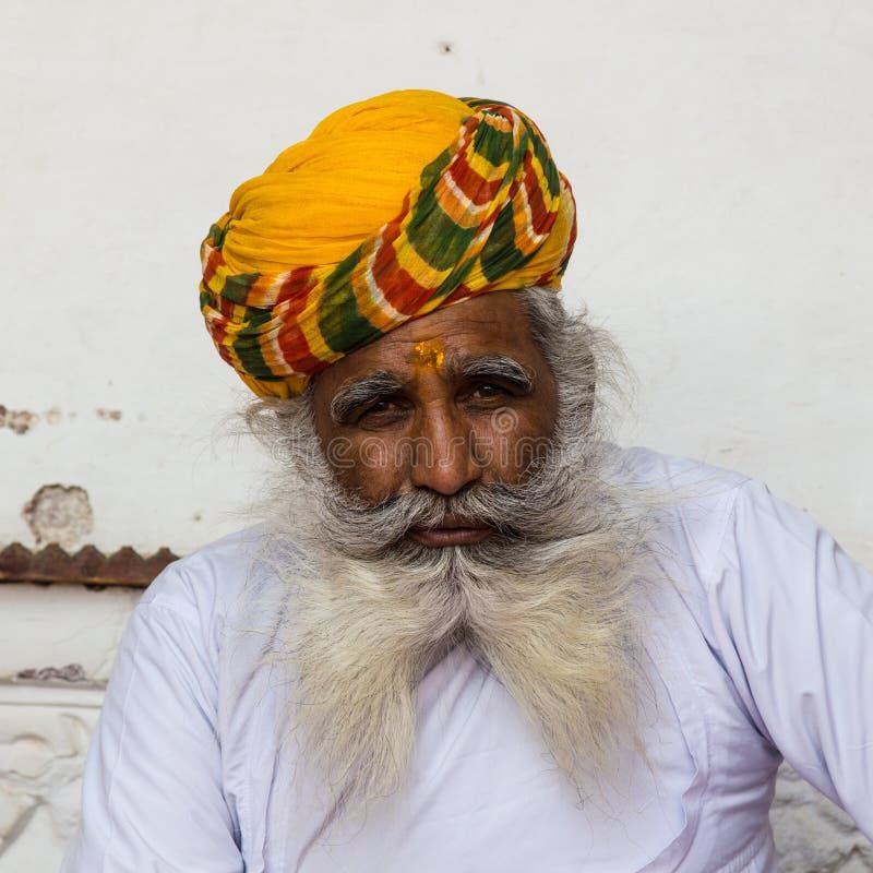 An old Indian man with a beautiful beard and yellow turban, Rajasthan, India