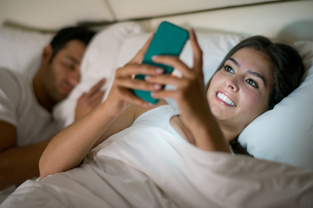 Woman-texting-in-bed-632824.jpg