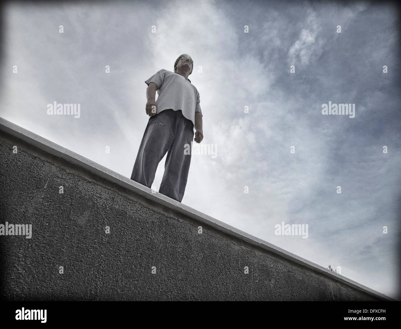 challenging-single-man-standing-on-a-ledge-DFXCFH.jpg