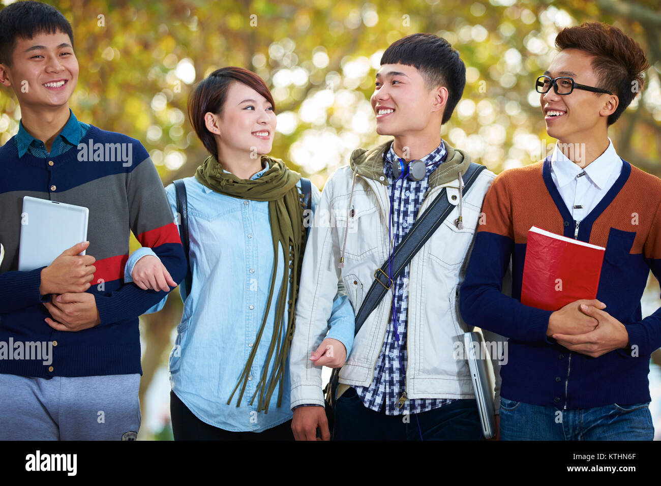 four-happy-asian-college-students-walking-together-in-the-campus-KTHN6F.jpg