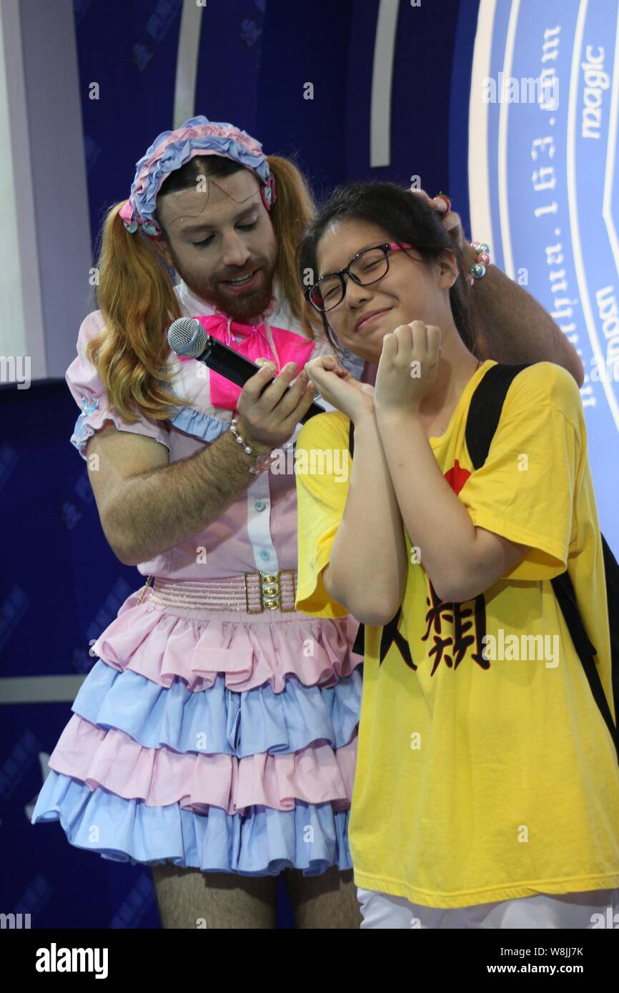 australian-cosplayer-richard-magarey-left-better-known-by-his-stage-name-ladybeard-dressed-in-a-girl-costume-speaks-to-a-girl-at-the-stand-of-netea-W8JJ7K.jpg