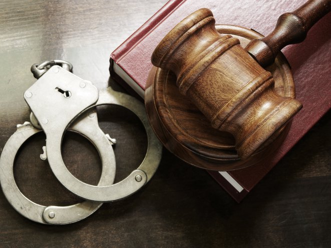 A stock photo of handcuffs and a gavel.
