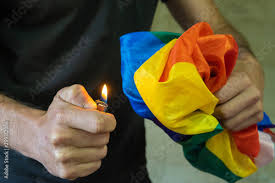 man burning lgbt flag with a cigarette lighter Stock Photo | Adobe Stock
