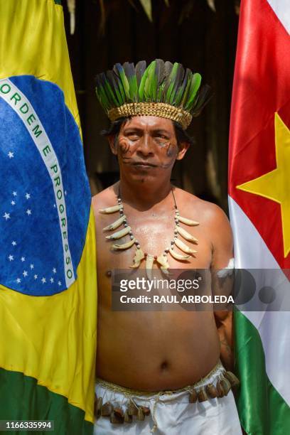 a-colombian-indigenous-tikuna-stands-besides-flags-of-brazil-and-suriname-during-the.jpg