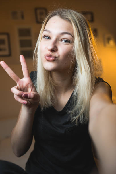 beautiful-cheerful-teenage-girl-taking-a-selfie-in-bedroom.jpg