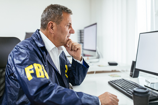 fbi-agent-using-computer-in-office-picture-id1171266198
