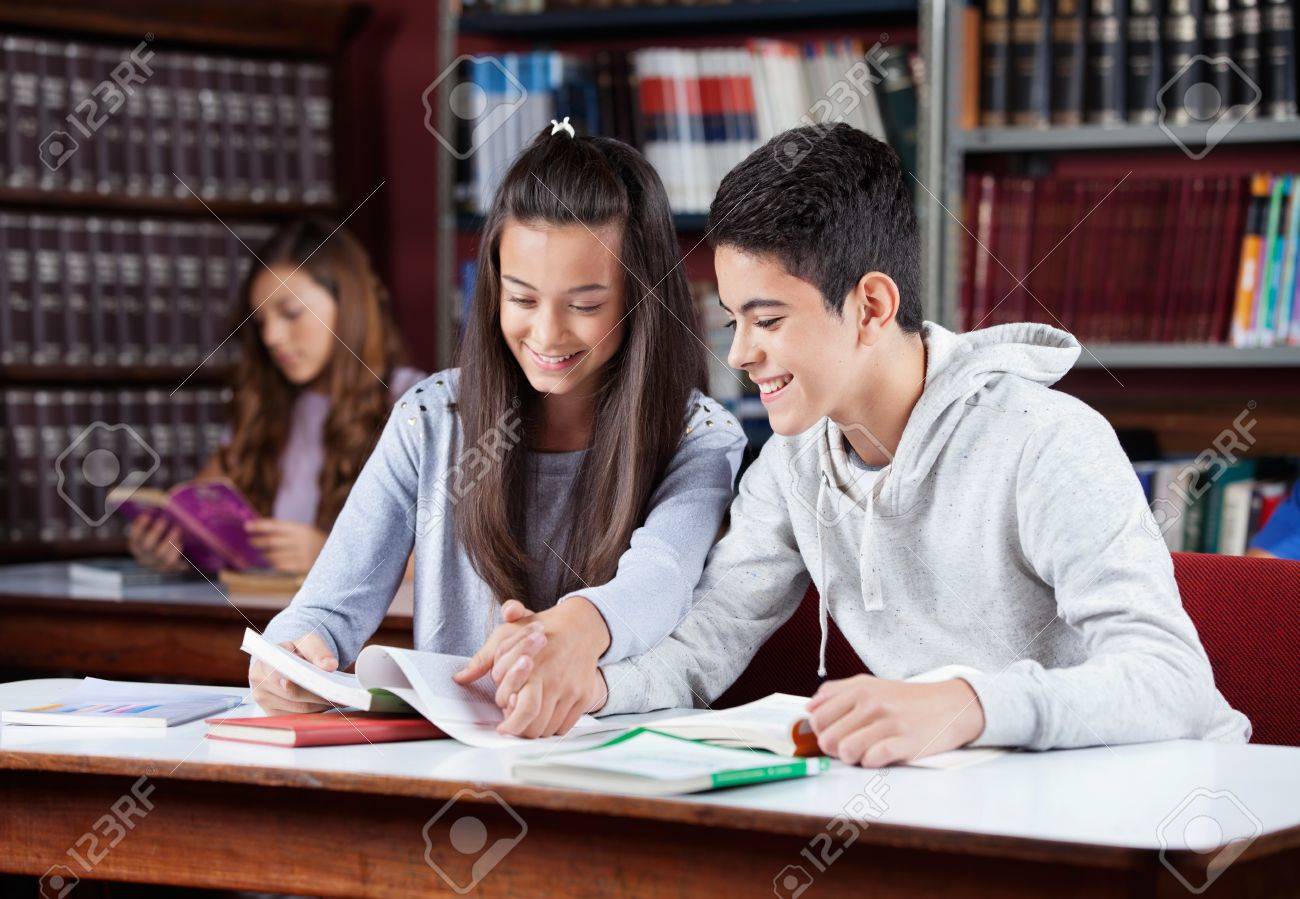 20601965-teenage-couple-studying-together-in-library.jpg