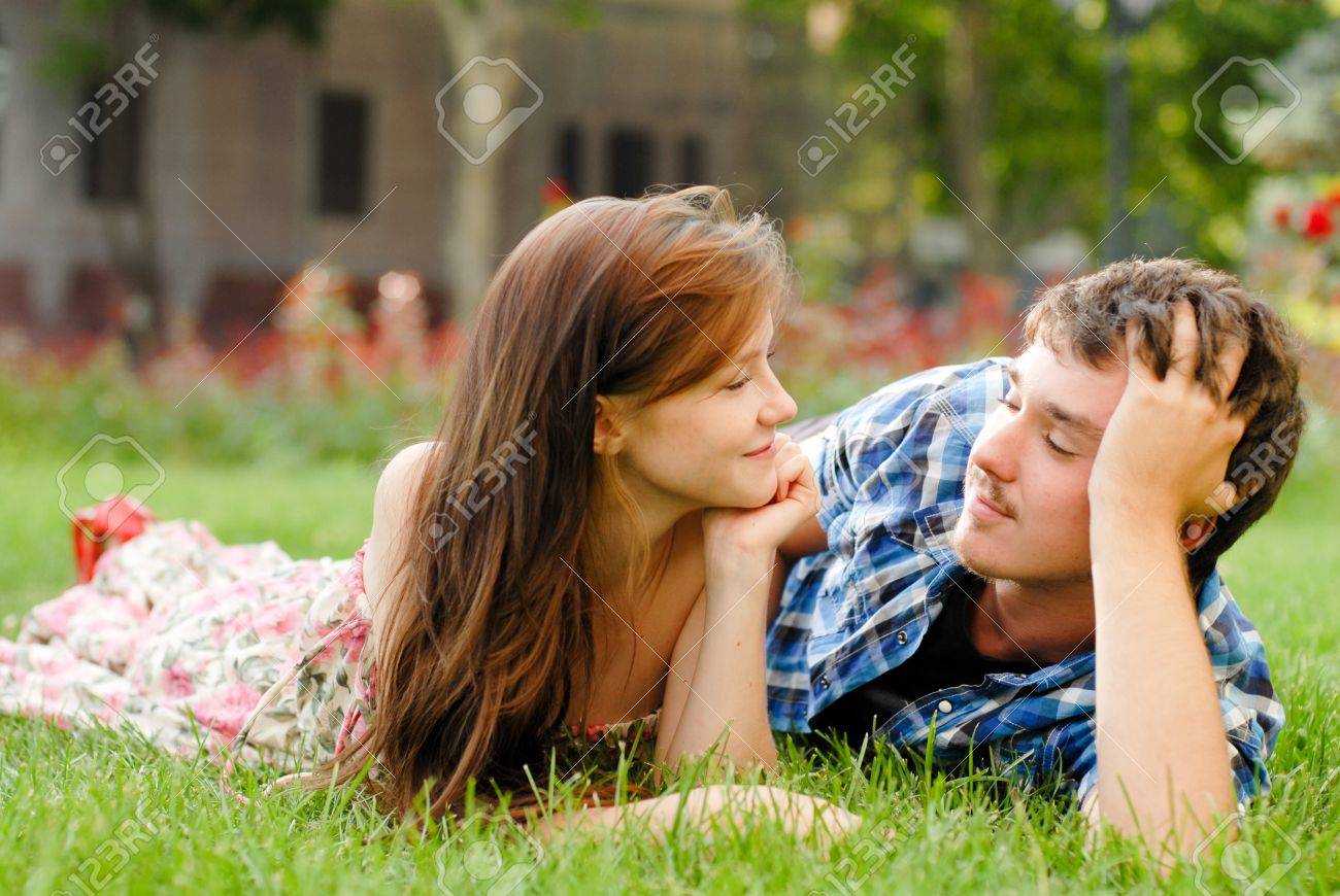 18061541-happy-young-teenage-couple-man-and-woman-in-love-lying-on-green-grass-in-city-park.jpg