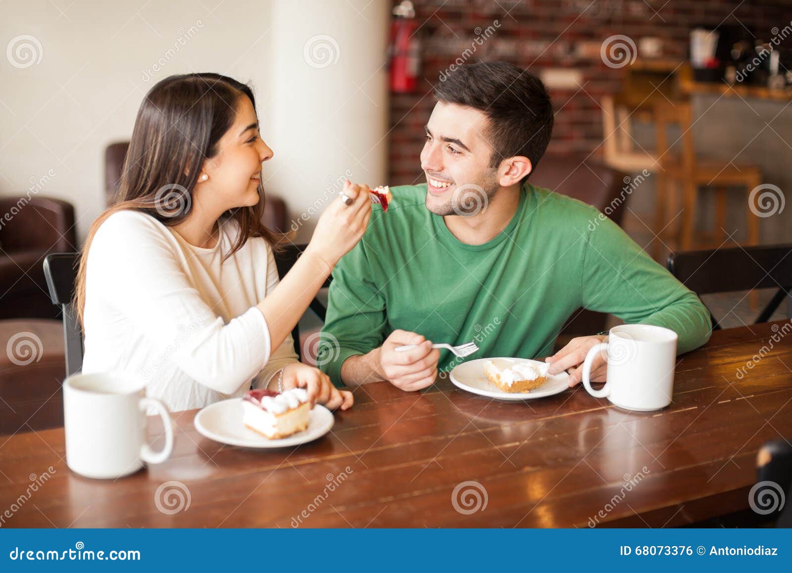 attractive-young-couple-sharing-food-cute-hispanic-having-good-time-together-coffee-shop-68073376.jpg